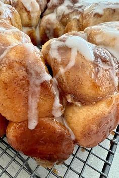 a bunch of doughnuts sitting on top of a cooling rack covered in icing