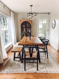 a dining room table and chairs in front of a window