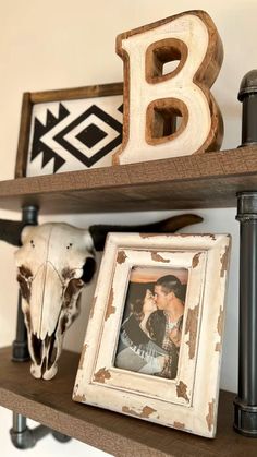 two wooden shelves with pictures and cow skulls on them, one holding a framed photo