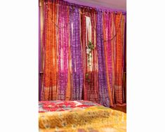 a bed room with a neatly made bed and colorful curtains