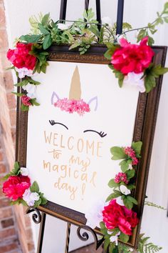 a welcome sign is decorated with flowers and an unicorn's head on it that says, welcome to my magic day