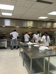 several chefs are in the kitchen preparing food