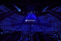 an auditorium with blue lights and people in it