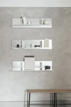 two white shelves with books and vases on them