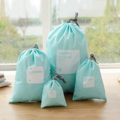 three blue bags sitting on top of a wooden table