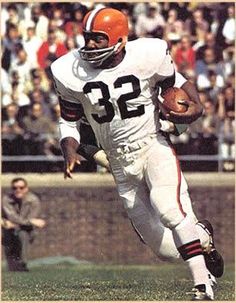 a football player runs with the ball in his hand as people watch from the stands