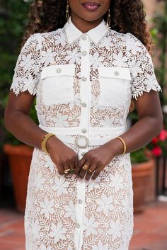 a woman wearing a white dress and gold bracelets