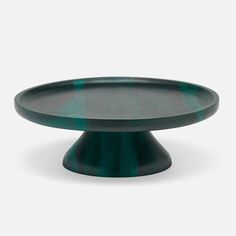 a black and green cake plate on a white background with no one around it or someone else