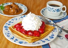 a plate with waffles, strawberries and whipped cream on it