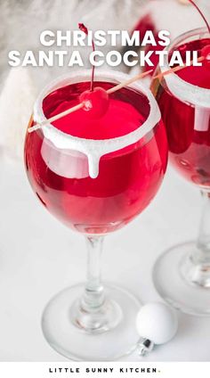 two glasses filled with red liquid and garnished with christmas santa's cocktail