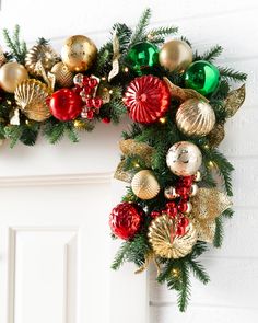 a christmas wreath is hanging on the wall next to a door with ornaments around it