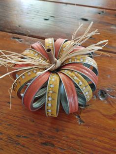 an ornament made out of strips of paper on top of a wooden table