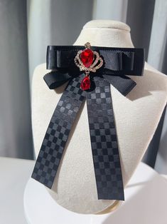 Add a touch of regal charm to your outfit with our rhinestoned crown bow tie/brooch. Available in both black and red, this versatile accessory features a dazzling rhinestone-encrusted crown design that exudes elegance and sophistication. Wear it as a bow tie or use it as a brooch to elevate your look with a hint of royal allure. Perfect for adding a touch of glamour to any outfit, this one-of-a-kind piece is sure to turn heads and make a statement. Whether you're dressing up for a special occasi Black Bow Tie Brooch For Wedding, Black Bow Tie Brooches For Wedding, Black Bow Tie Jewelry For Party, Elegant Red Pins For Party, Elegant Red Party Pins, Black Brooch With Decorative Bow For Evening, Formal Black Brooch With Decorative Bow, Black Bow Tie Jewelry For Formal Occasions, Formal Red Rhinestone Brooch