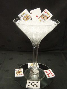 a glass filled with cards sitting on top of a table