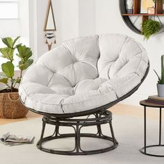 a white chair sitting on top of a metal stand next to a potted plant