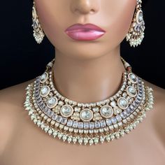 Adorn yourself with timeless elegance with our Bridal White Fine Kundan Gold Plated Necklace Set. Perfect for Indian and Pakistani weddings, this exquisite bridal jewelry features intricate gold-plated designs and sparkling kundan stones. Experience the allure of tradition and make your special day unforgettable. Gold-plated foiled Kundan necklace set. Regular Size And Adjustable Ships from California, USA Delivery in 2-5 business days in the USA. Color, shades, and texture displayed may slightly vary from the actual product due to digital image limitations. We request you consider these minor variations. Please expect the possibility of some slight imperfections when buying handmade jewelry. Please let me know if you have any questions. Arrives in a gift box. Thank you so much for visitin Bollywood Kundan Bridal Accessories For Marriage, White Jewelry Sets With Stone Work For Ceremonial Occasions, Ceremonial White Jewelry Sets With Stone Work, White Kundan Necklace With Intricate Design For Wedding, Heavy Kundan Bridal Accessories For Wedding, White Kundan Necklace With Intricate Design For Marriage, White Kundan Necklaces For Marriage, White Stone Work Jewelry Sets For Ceremonial Occasions, Silver Bollywood Bridal Necklace For Marriage