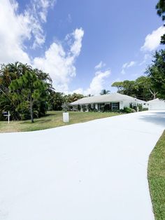 a white house sitting on top of a lush green field