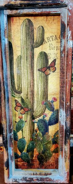 an old wooden frame with a painting of a cactus and butterflies on the front side