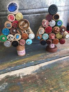 two christmas trees made out of wine corks with buttons and magnets on them