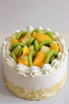 a white cake topped with fruit on top of a table