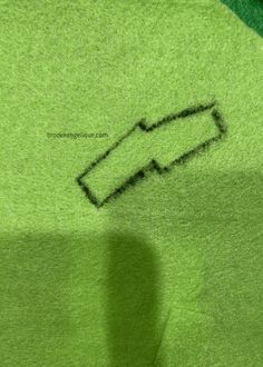 a green t - shirt with a black arrow drawn on it