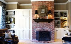 a living room filled with furniture and a fire place in front of a brick fireplace