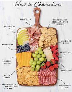 a cutting board with different types of cheeses, crackers and fruit on it