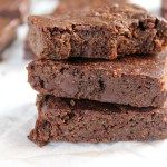 three pieces of brownie stacked on top of each other in front of a white background