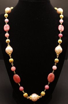 This necklace is truly enchanting especially if you love the colors of pink and more pink!  The necklace features oval pink agate beads and light pink glass pearls along with gold corrugated metal beads and rhodonite and jade stone beads in many different colors of pink and the pearls have beautiful gold bead caps with a heart design.  The necklace is finished with a gold chain and a lobster clasp.  Necklace is 32" long. You have a choose of 2 earrings--(A) 2-stone pink beads with center rhinestone gold spacer and rhinestone posts; (B) features light pink glass pearls and rhinestone spacers and gold bead caps completed with  fancy gold filigree posts.   1 set of earrings are included in the price of the necklace.   Note:  This necklace is all 'hand-made' with gold eye pins which gives the Pink Agate Beaded Necklaces As Gift, Elegant Pink Pearl Necklace With Gemstone Beads, Pink Agate Beaded Necklaces, Pink Agate Beaded Necklace, Pink Pearl Necklace With Faceted Beads As Gift, Pink Polished Beads Pearl Necklace As A Gift, Pink Polished Bead Pearl Necklace For Gifts, Pink Polished Beads Pearl Necklace For Gifts, Pink Polished Bead Necklace For Gift