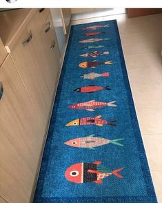 a blue rug with fish on it is in the middle of a kitchen floor next to cabinets