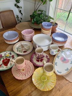 a wooden table topped with lots of plates and bowls