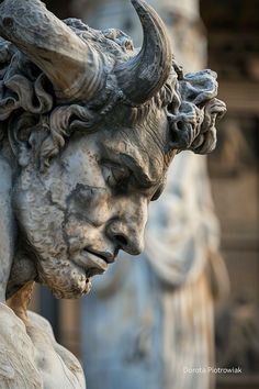 a close up of a statue of a man with horns on it's head