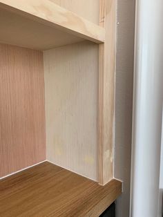 an empty shelf in the corner of a room with wood paneling on it's sides