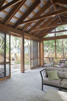 a living room filled with furniture and lots of glass doors opening up to a covered patio