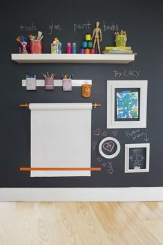 the chalkboard is on the wall next to some shelves with pictures and art supplies