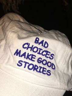 a white hat with the words bad choices make good stories written on it in blue ink