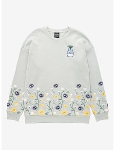 a white sweatshirt with flowers on it and a blue vase in the middle is shown