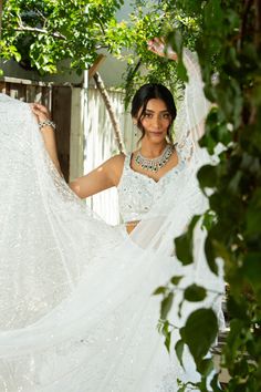 Ivory white lehenga with all over mirror and sequin embellished work enveloped by scalloped border ,paired with a mirror work studded fully embroidered blouse ! Comes along with embroidered dupatta which is also studded with mirror work, enveloped with scallop border and hanging tassels. Color - Ivory white Fabric & Work Style - - Soft Net lehenga: Sequin, mirror work. - Mirror work & Embroidered blouse. - Mirror work & Embroidered dupatta. Details - - Assured quality. - Wash care instruction: D Buy Lehenga Online, Indian Bridal Couture, Elegant Veils, Hanging Tassels, Fremont California, Reception Gowns, White Lehenga, Mehendi Outfits, Indian Clothing Store