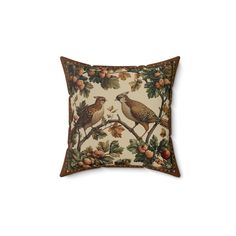 a decorative pillow with two birds on the branch and pine cones in the background,