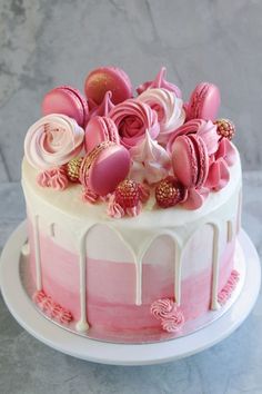 a pink and white cake with frosting on top