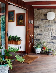 a room with plants and pictures on the wall