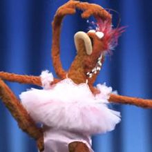 a stuffed animal in a tutu dancing on stage