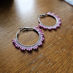 Hand woven hoop earrings created with White crystal pearls and fine glass seed beads in shades of Pink delicately woven onto Stainless Steel hoops.     👉  Arrives in a gift box with bow, ready for giving. 🎁 👉  Measurements:  2 inches around. 👉  Lightweight and easy to wear 👉  304 Stainless Steel hoops 👉  Miyuki and Toho glass seed beads 👉  White crystal pearls 👉  Thermally-fused extra strong thread For different colorways and styles, visit my shop:  https://www.etsy.com/shop/CyntheCreations ⭐  THINGS TO KNOW ABOUT BEADED JEWELRY:  While sealed for normal wear, glass beads are NOT WATERPROOF and should not be worn when swimming or bathing.      Pattern Design by Breanna Deis Silver Beaded Hoop Earrings As Gift, Pink Metal Dangle Beaded Earrings, Pink Hoop Beaded Earrings For Party, Pink Beaded Metal Earrings, Festive Beaded Hoop Earrings With Round Beads, Festive Beaded Hoop Earrings, Metal Beaded Earrings With Round Beads For Festivals, Metal Beaded Earrings For Festivals, Festival Metal Beaded Earrings With Round Beads