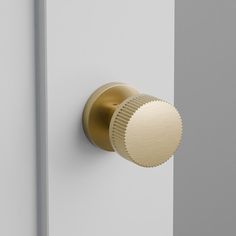 a close up of a door knob on a white and gray door with a gold handle