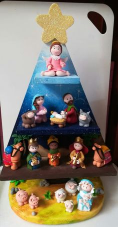 a christmas tree made out of small figurines on top of a wooden shelf