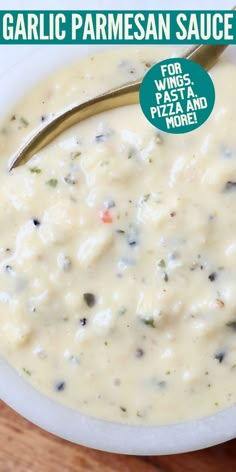 a bowl of garlic parmesan sauce with a spoon in it on a wooden table