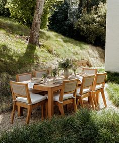 a wooden table with white chairs around it