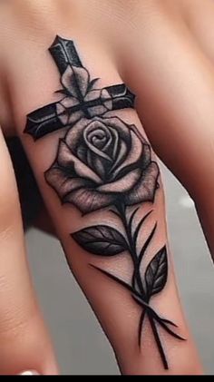 a rose with a cross tattoo on it's left arm and the other hand