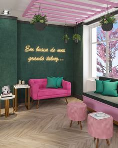 a living room with green walls and pink furniture in the corner, along with potted plants