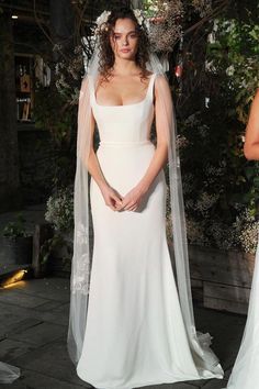 two women in wedding dresses standing next to each other